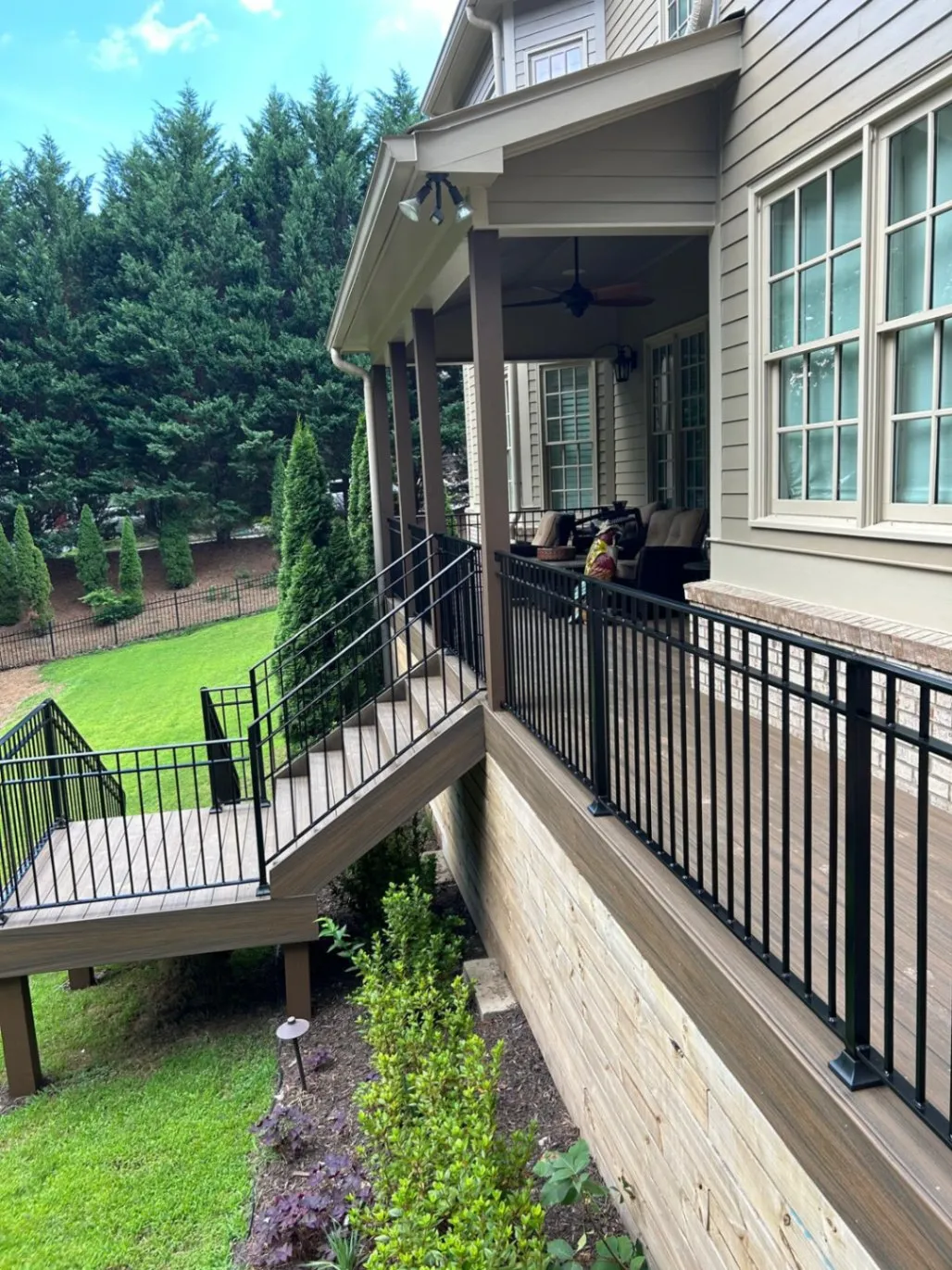 Custom black metal railings on outdoor wooden stairs and porch deck installed by R&R Construction Services in Roswell, GA.