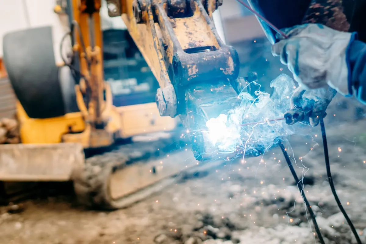 Heavy construction machinery welding repair on an excavator arm by R&R Construction Services in Roswell, GA.