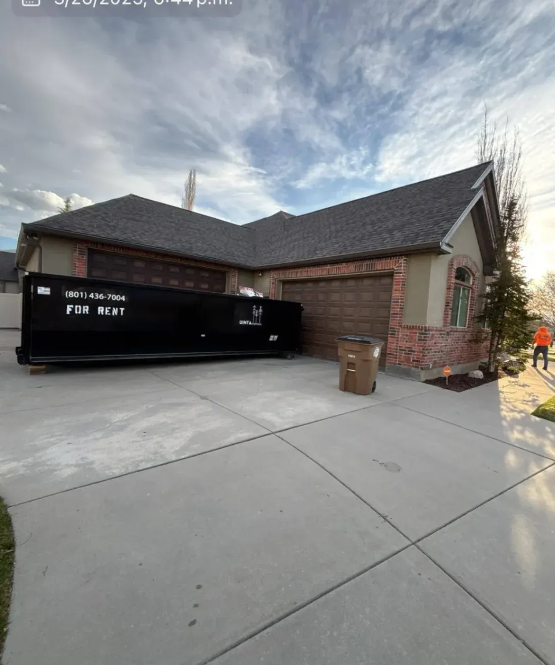 View of a residential roof with a dark shingle design, captured in bright daylight. The roof is in excellent condition with no visible damage.