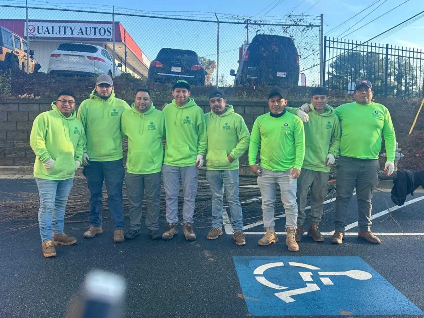 Team of professional landscapers from Georgia Landscaping and Hardscaping standing together in branded green uniforms, representing trusted landscaping services in Milton, GA.