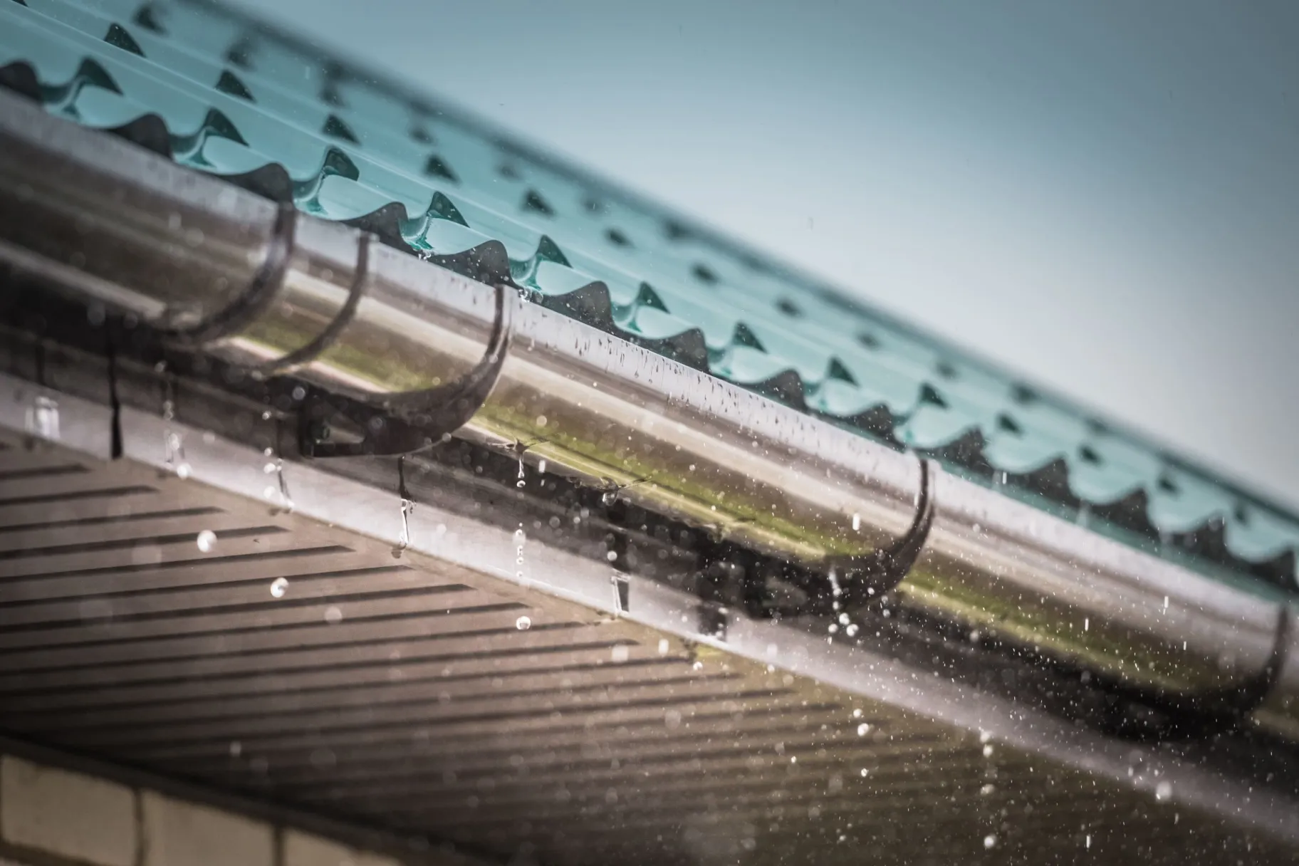 Rain flowing down from a roof down - Commercial Roofing in Sunbury, NC