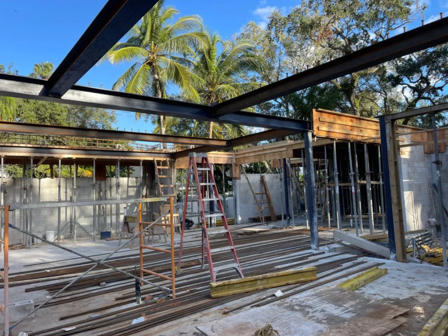 An outdoor active construction site in Coral Springs featuring a heavy structural steel I-beam framework constructed by Abel Welding Services Inc.