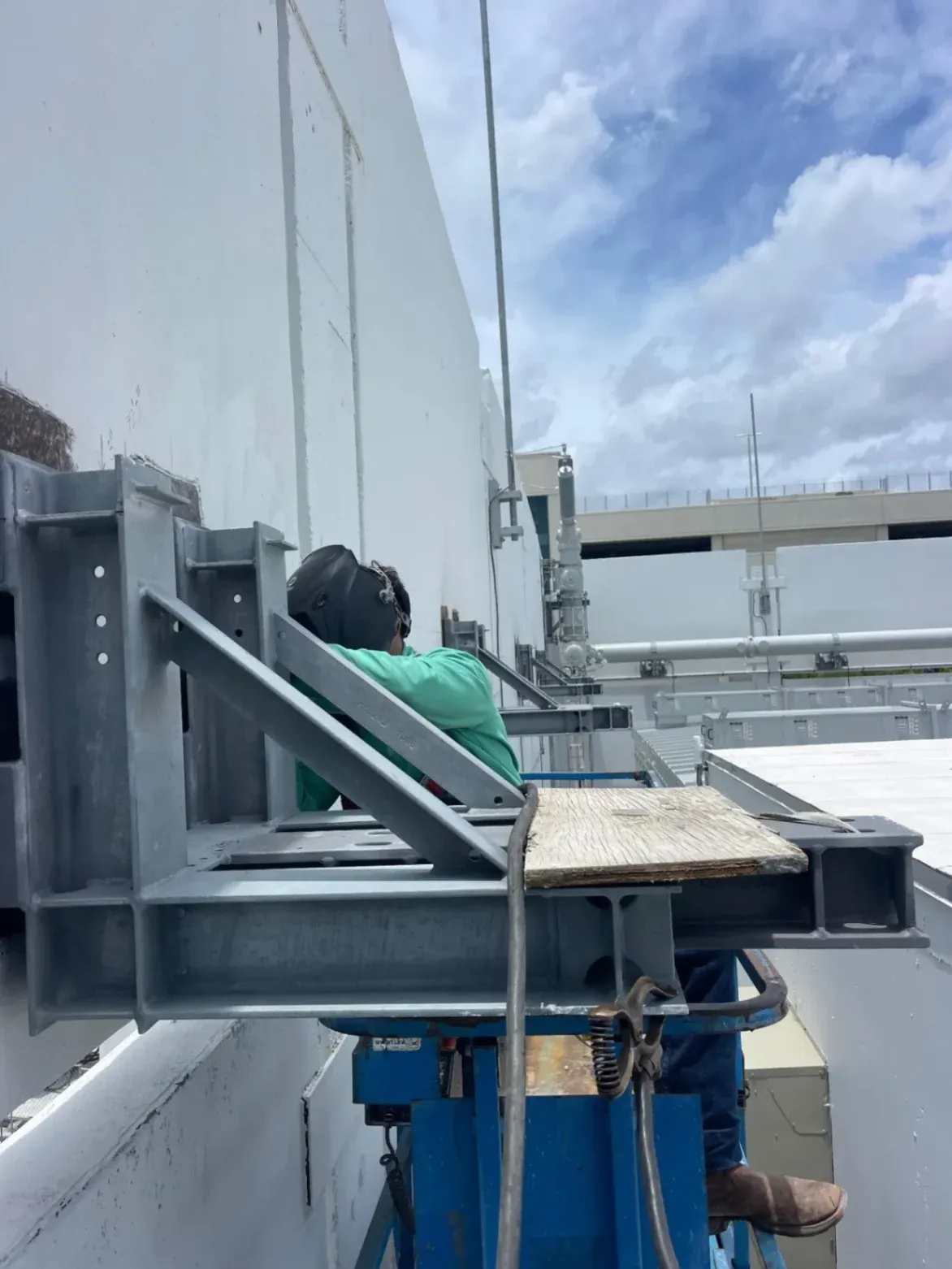 AWS-certified commercial welding contractor from Abel Welding Services Inc. installing heavy-duty mechanical equipment supports on a rooftop near Miramar, FL.