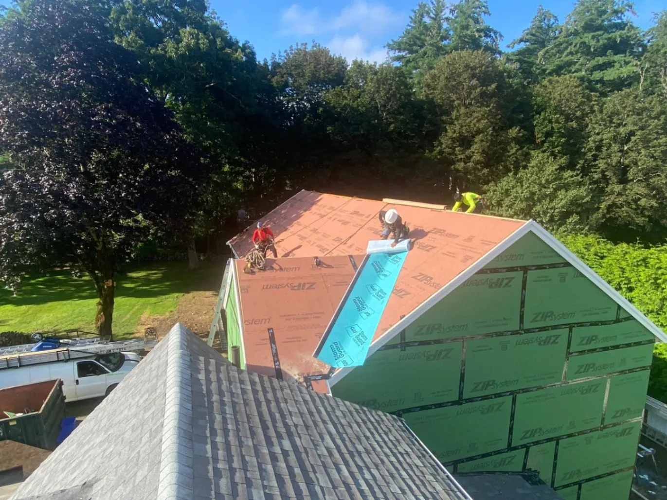 Professional JM Exteriors Roofing Siding roofers installing a GAF StormGuard leak barrier and ZIP System sheathing during a full roof replacement in Westford, MA.