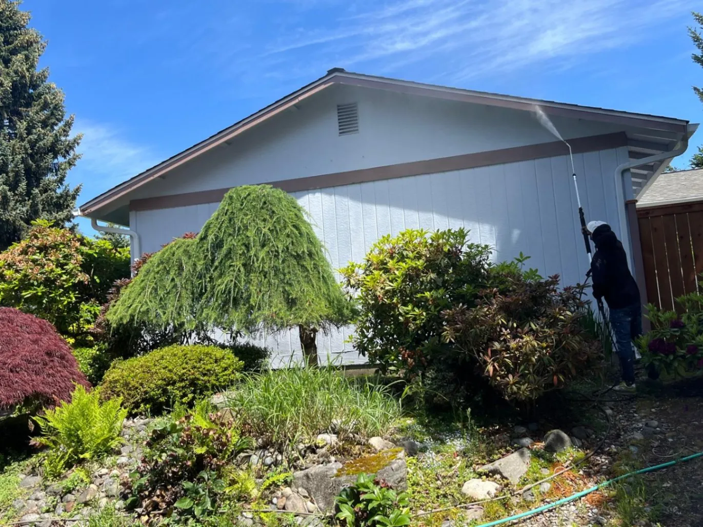 AC Pro Painting starts by pressure washing exterior walls to clean off dirt and old paint.