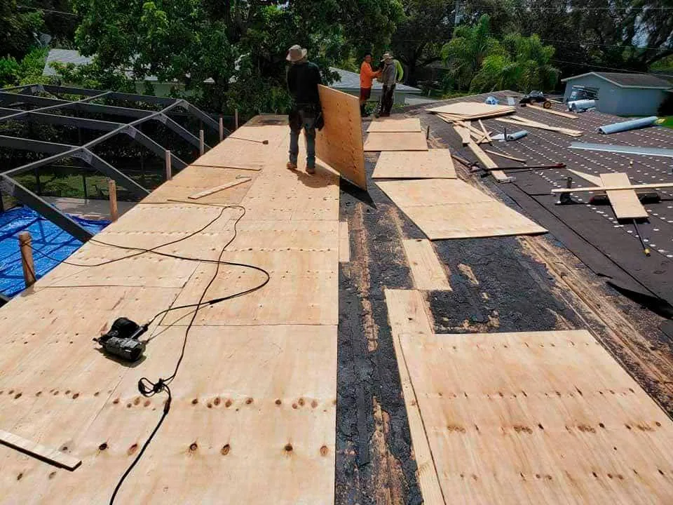 3 men working hard in a roof replacement project