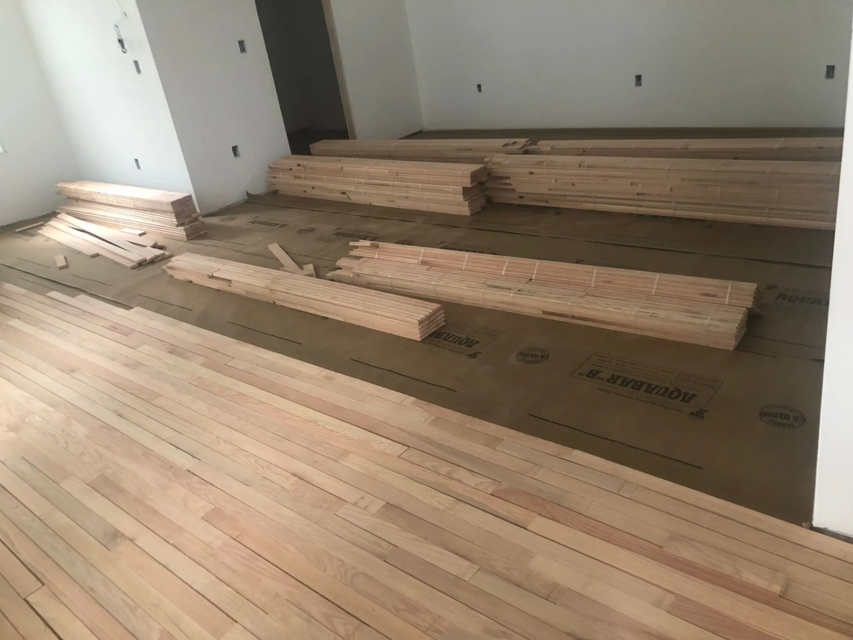 Precision hardwood flooring installation over Aquabar moisture barrier by DNH Hardwood Flooring LLC in Apex, NC.