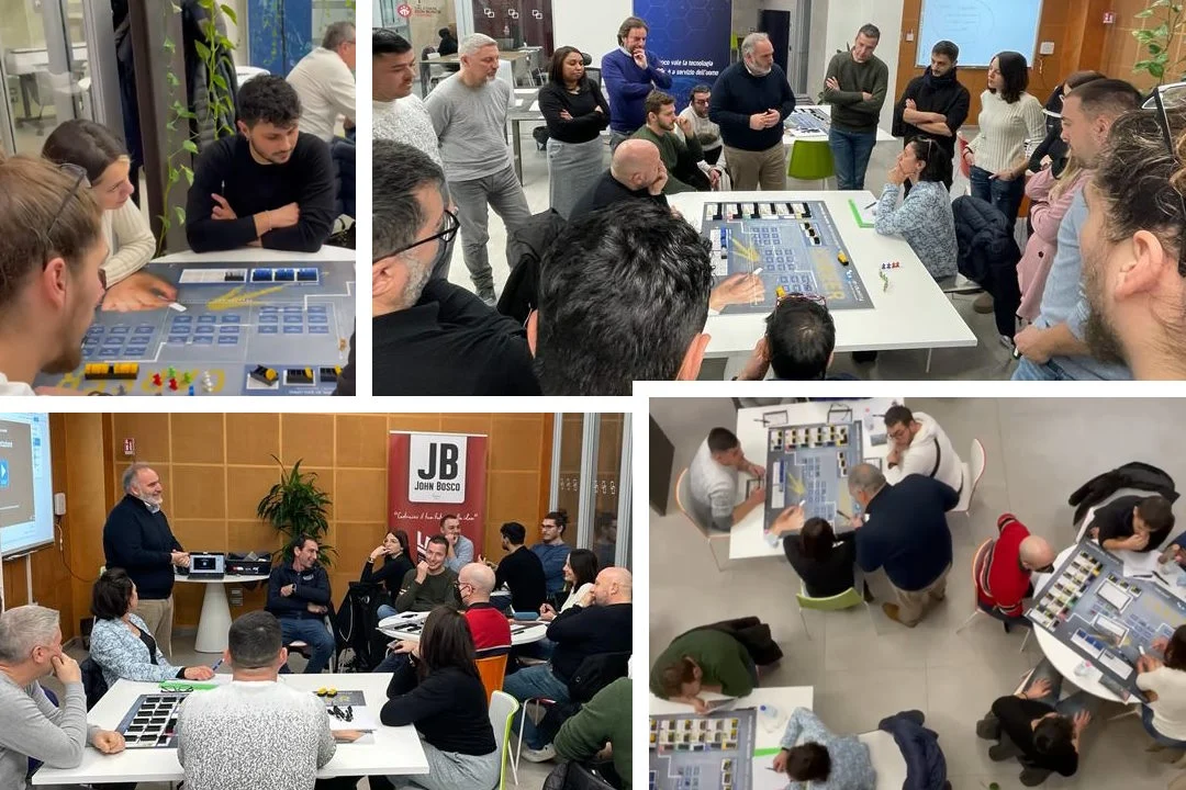 Ecco una didascalia per l'immagine:

"Persone partecipano a un'attività di team building con un gioco da tavolo che simula un layout di magazzino. I gruppi lavorano insieme su strategie, mentre un facilitatore conduce la sessione."