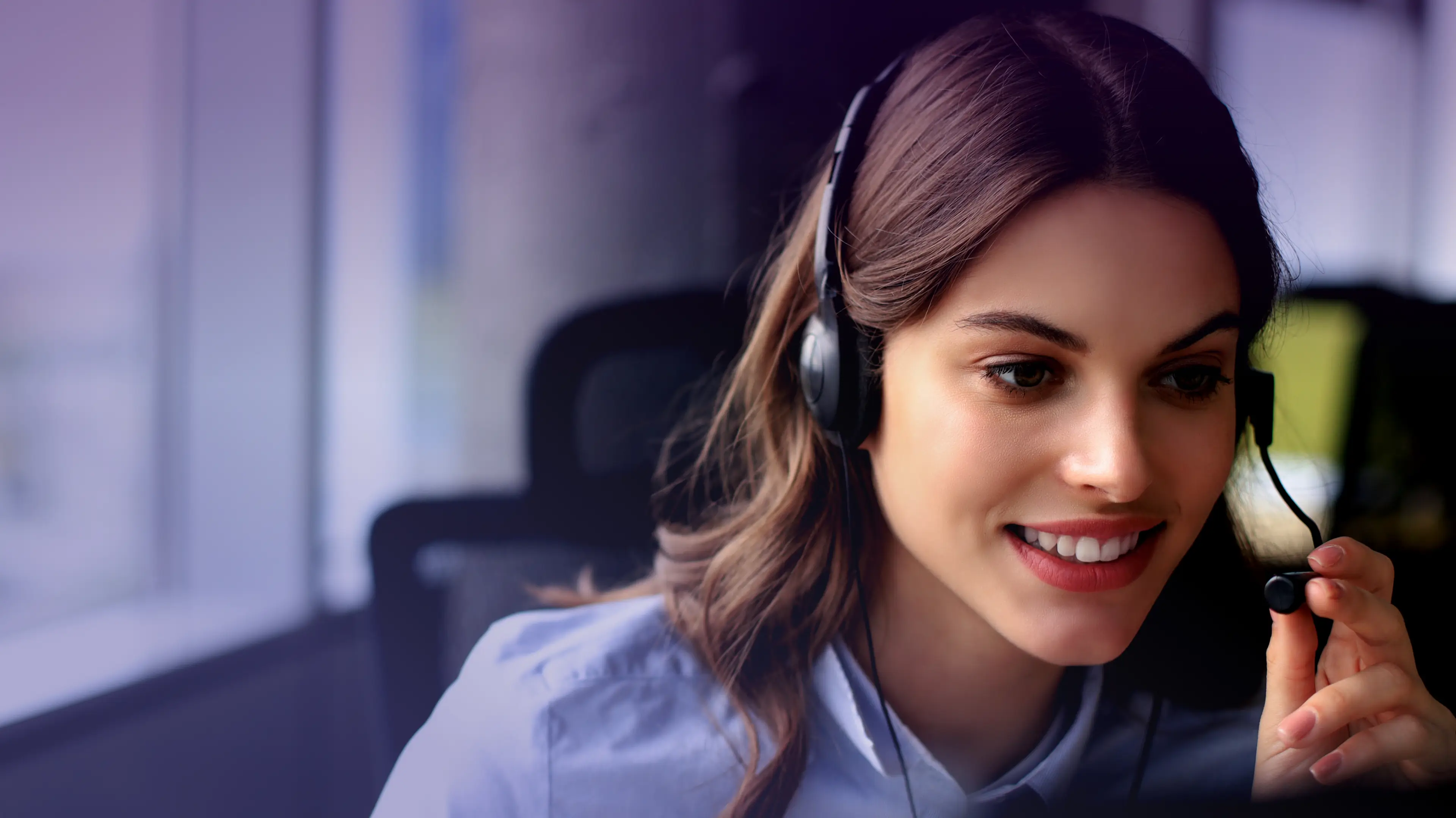 Operatrice del call center sorridente che indossa una cuffia.