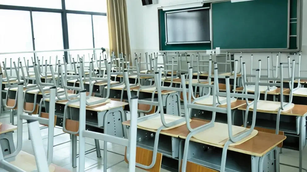 Ecco una didascalia per l'immagine:

**Un'aula vuota con sedie sui banchi.**