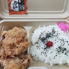 Un bento con un gran pollo frito.