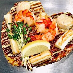 海老、イカ、貝柱、豚など入った見栄えがあるお好み焼き