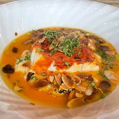 真鯛の表面に「ロメスコソース」を塗り、オーブンで焼き上げる