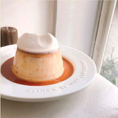 A luxurious dish of large handmade pudding topped with cream.