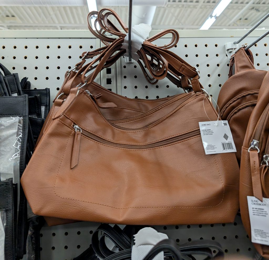 Brown faux-leather hobo bag from a value store, featuring a shoulder strap and multiple zippered pockets for daily essentials.