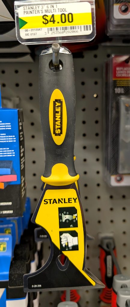 Black and yellow Stanley 6-in-1 painter's multi-tool from Dollarama, $4, perfect for scraping, spreading, and cleaning.