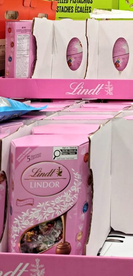 Pink boxes of Lindt Lindor assorted chocolate truffles from Costco, $23.99, featuring creamy melting centers.