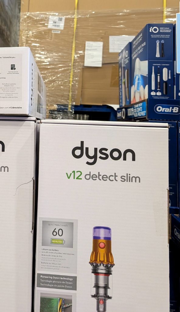 Dyson V12 Detect Slim cordless vacuum in its white packaging from Costco, priced at $649.99 for powerful home cleaning.