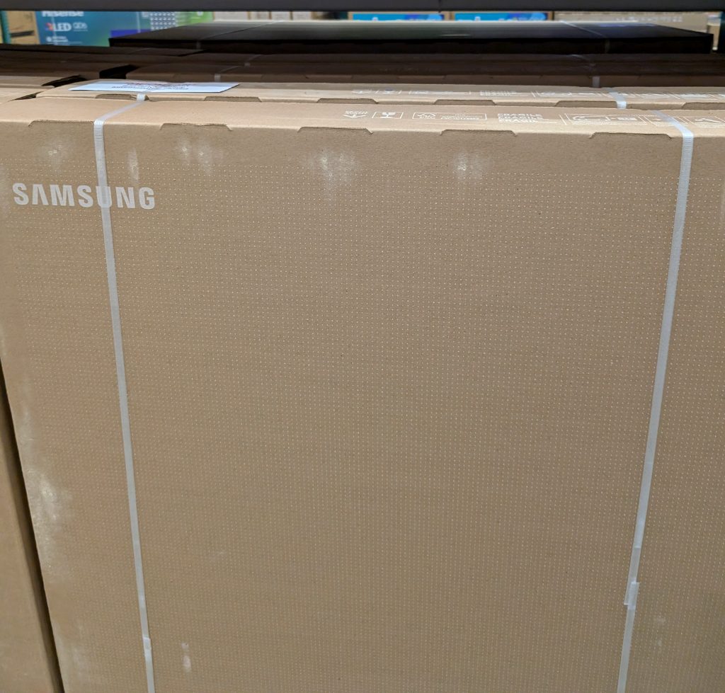Large Samsung 75-inch 4K UHD LED TV in a brown cardboard box, available at Costco for home entertainment.