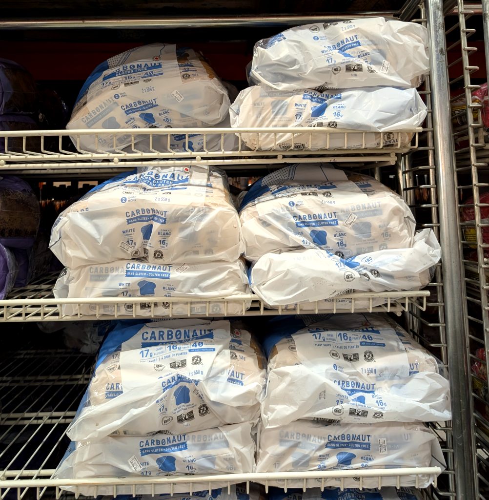 Carbonaut gluten-free white bread (2x550g) in white and blue packaging on a shelf at Costco, priced at $10.99.