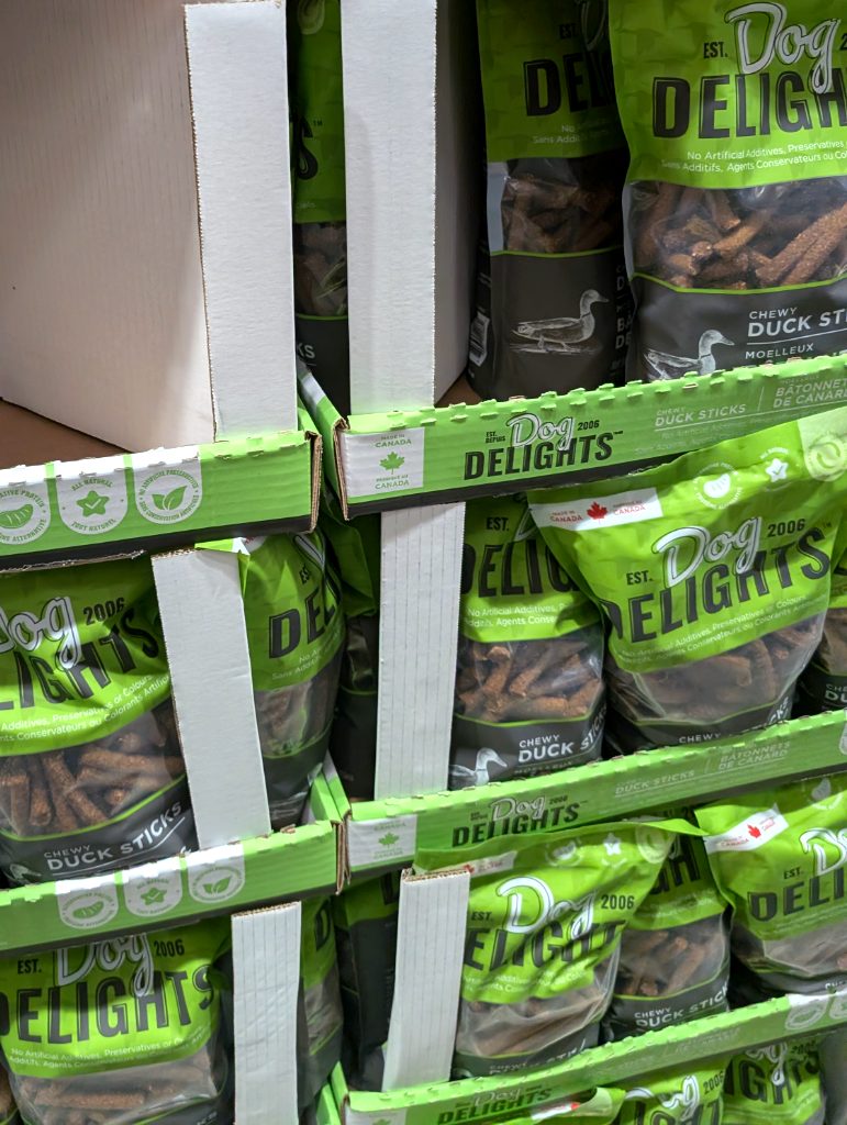 Dog Delights Chewy Duck Sticks, 1.25kg bags, natural dog treats, displayed on shelf at Costco for $15.99.