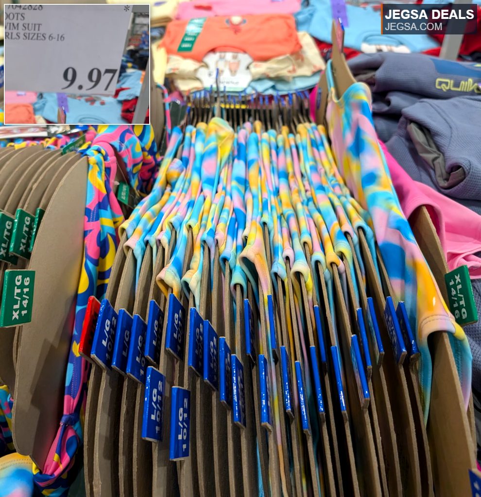 ROOTS girls' tie-dye swimsuits, sizes 6-16, displayed at Costco for $9.97. Ideal for pool parties and beach days.