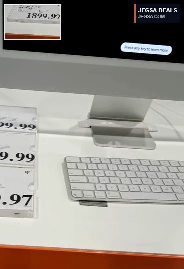 Silver 24-inch Apple iMac with M4 chip, wireless keyboard, and display on a white desk from Costco for $1899.97.