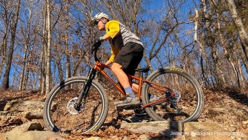 Mountain Biker Rolling Over Rocky Terrain