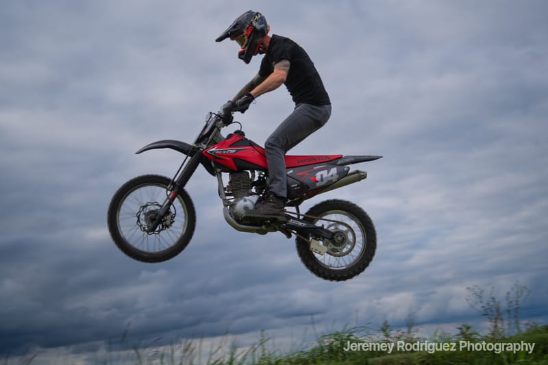 Dirt Bike Rider Soaring Against Gray Sky
