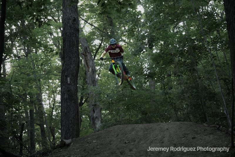 Mountain Biker Airborne in the Forest
