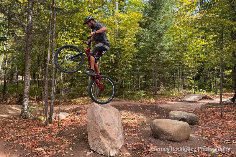Rider Perched Atop a Forest Boulder