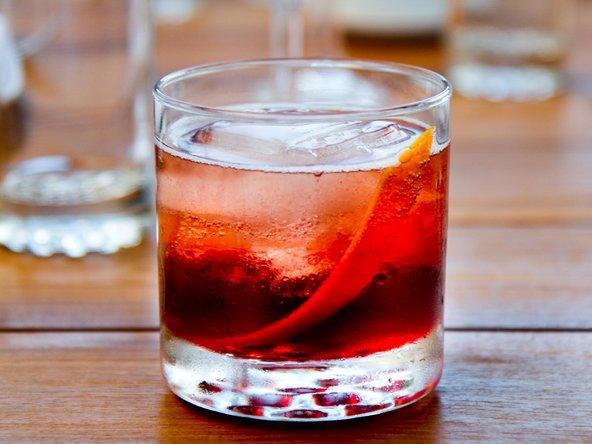 Negroni cocktail in a lowball glass with clear ice and orange slice