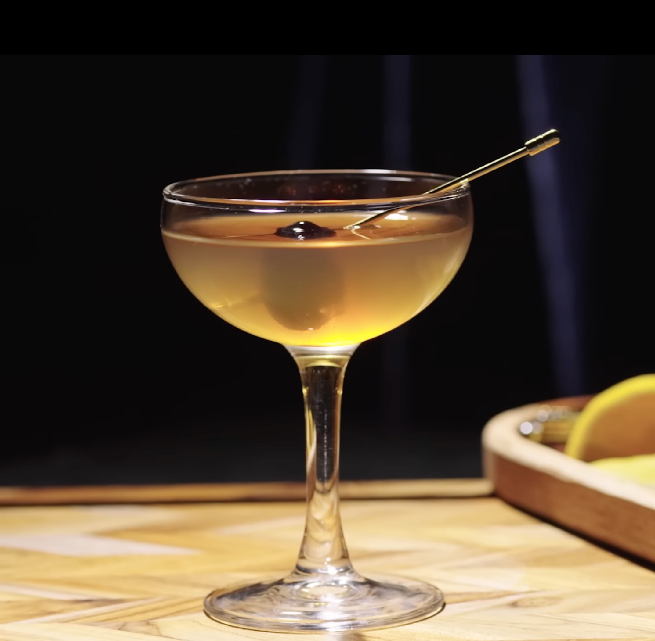 Little Baloney cocktail in a coupe glass with cherry garnish