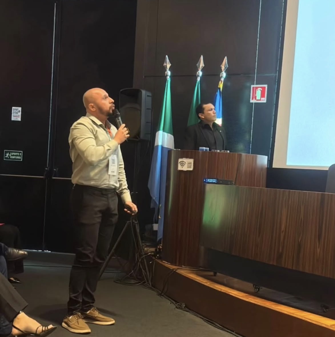 Palestra em auditório com bandeiras oficiais
