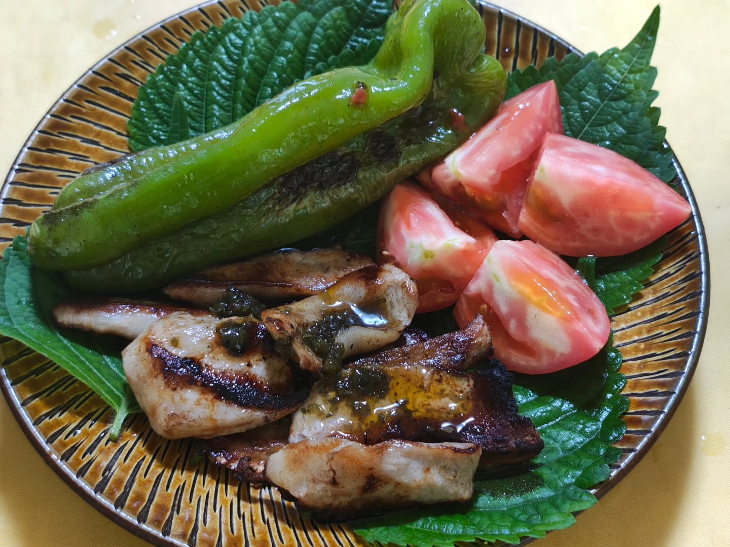 Hachioji tomatoes, perilla leaves, and pork jowl seared on a cast-iron skillet