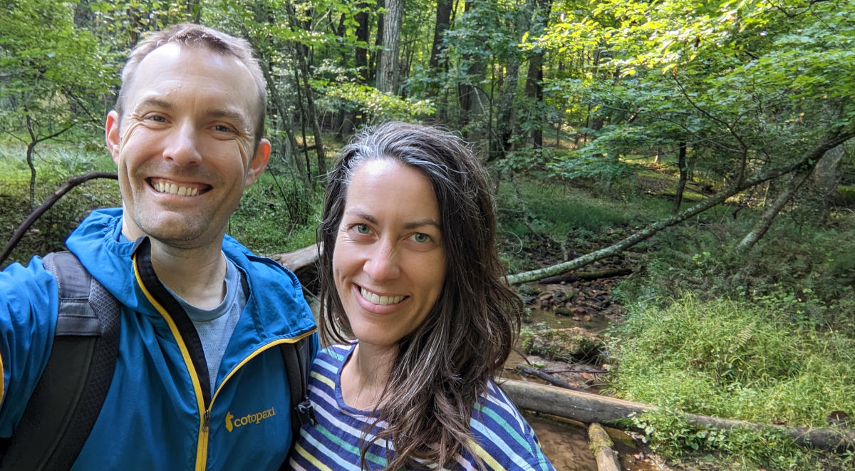 Photo of founders, Nicholas and Anne, in a forest