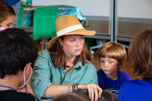 A camp counselor showing a wildlife mammal to kids