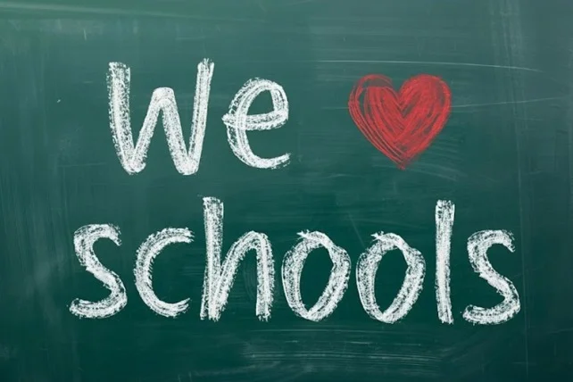 Chalkboard with “We ♥ schools” written in white chalk and a red heart