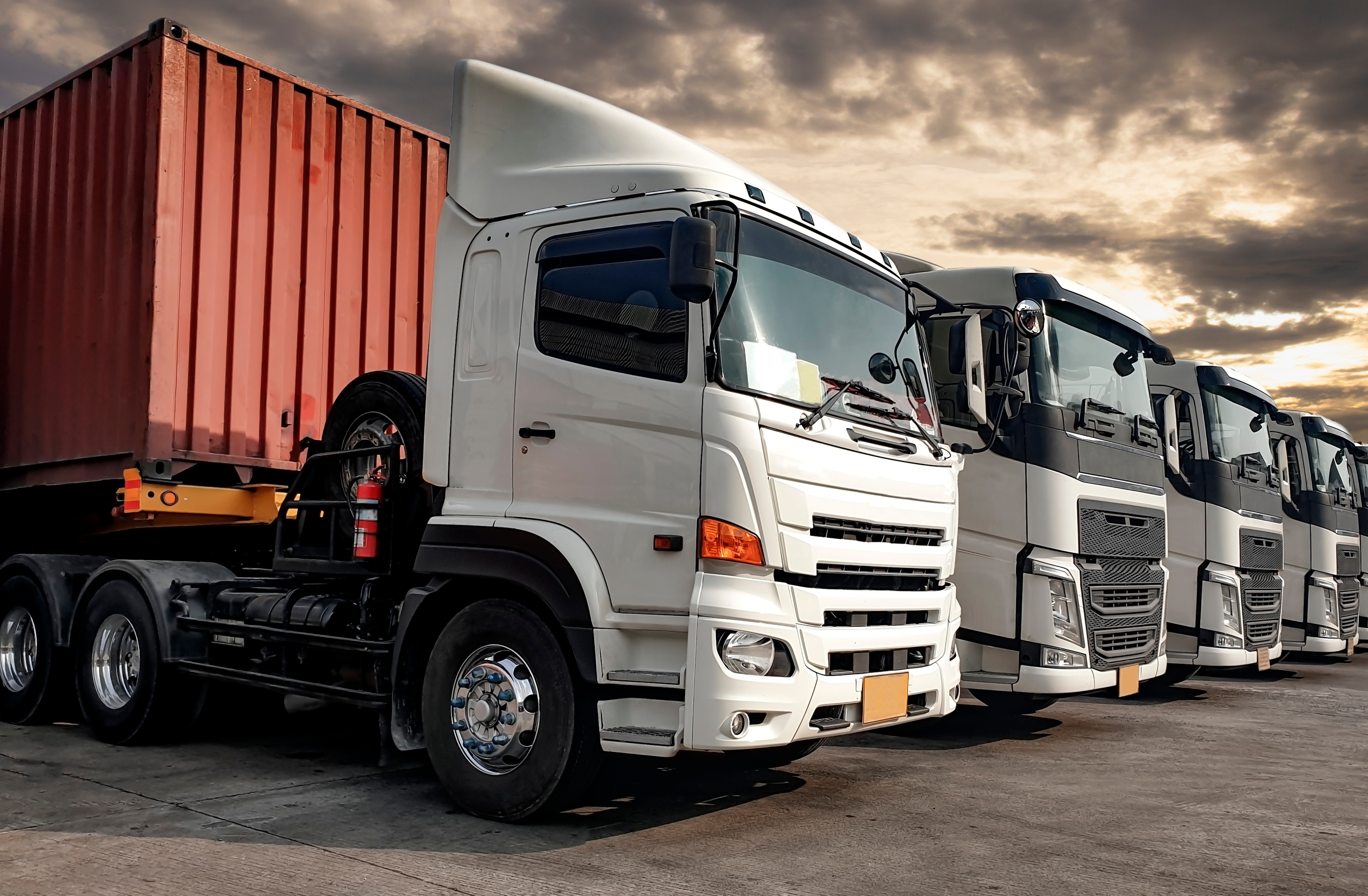 A row of modern trucks ready to tackle the challenges of road freight logistics
in 2024, showcasing the latest advancements and trends in the industry.