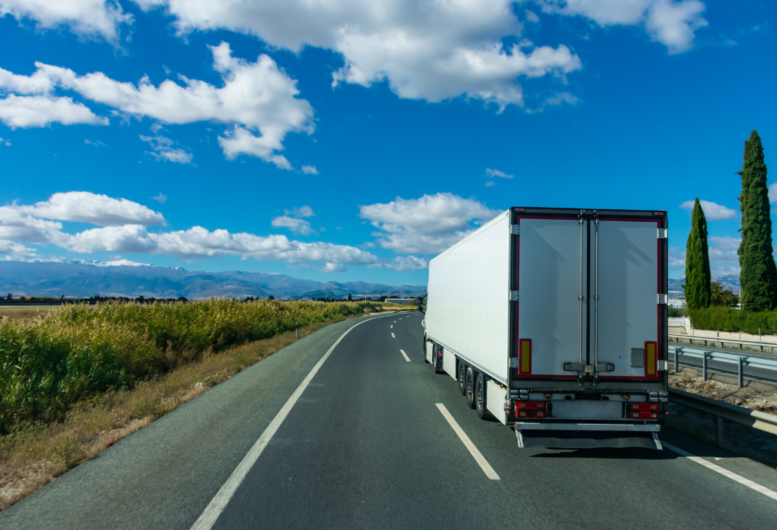 A refrigerated truck travelling on a clear, open highway, highlighting the importance of efficient route planning in cold chain logistics to maintain temperature control, ensure timely deliveries, and reduce operational costs.