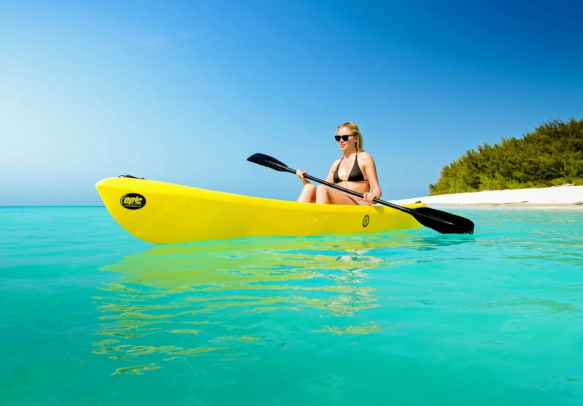 Woman kayaking in turquoise water