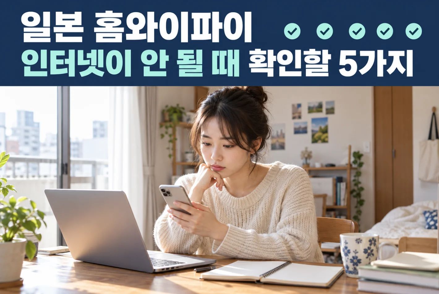 일본 자취방에서 노트북 옆에 앉아 스마트폰의 인터넷 연결 상태를 확인하는 유학생