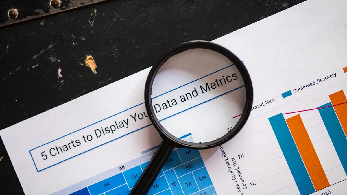 Magnifying glass examining numerical data representing keyword search volume measurement and analysis