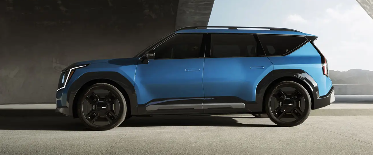 Vue 3/4 avant et latérale du Kia EV9 2025, garé dans un stationnement sous-terrain