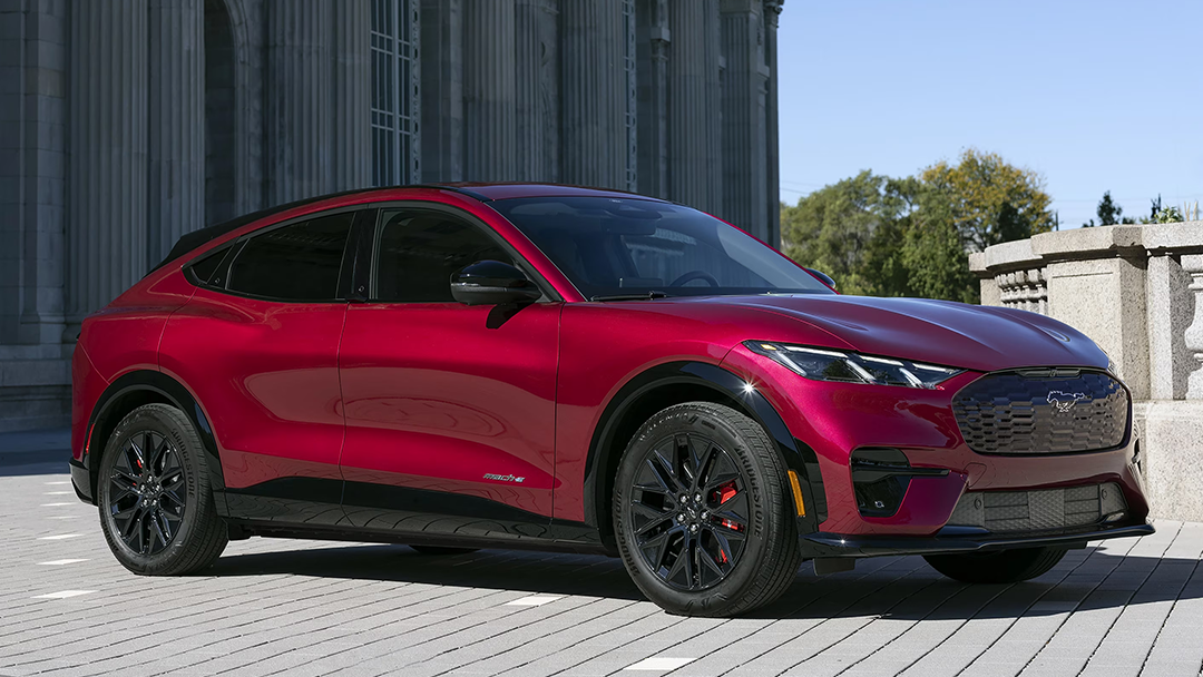 Vue 3/4 avant et latérale du Ford Mustang Mach-E, garé devant une eglise sur une cour pavé