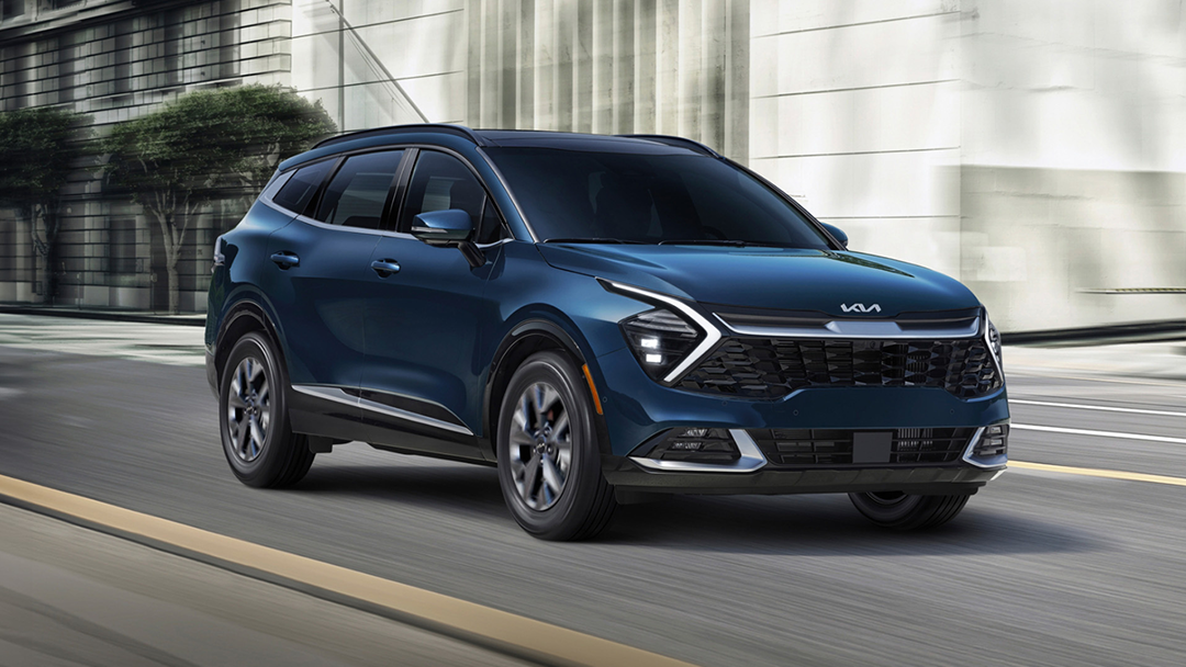 Vue 3/4 avant et latérale du Kia Sportage 2025 sur route en pleine puissance