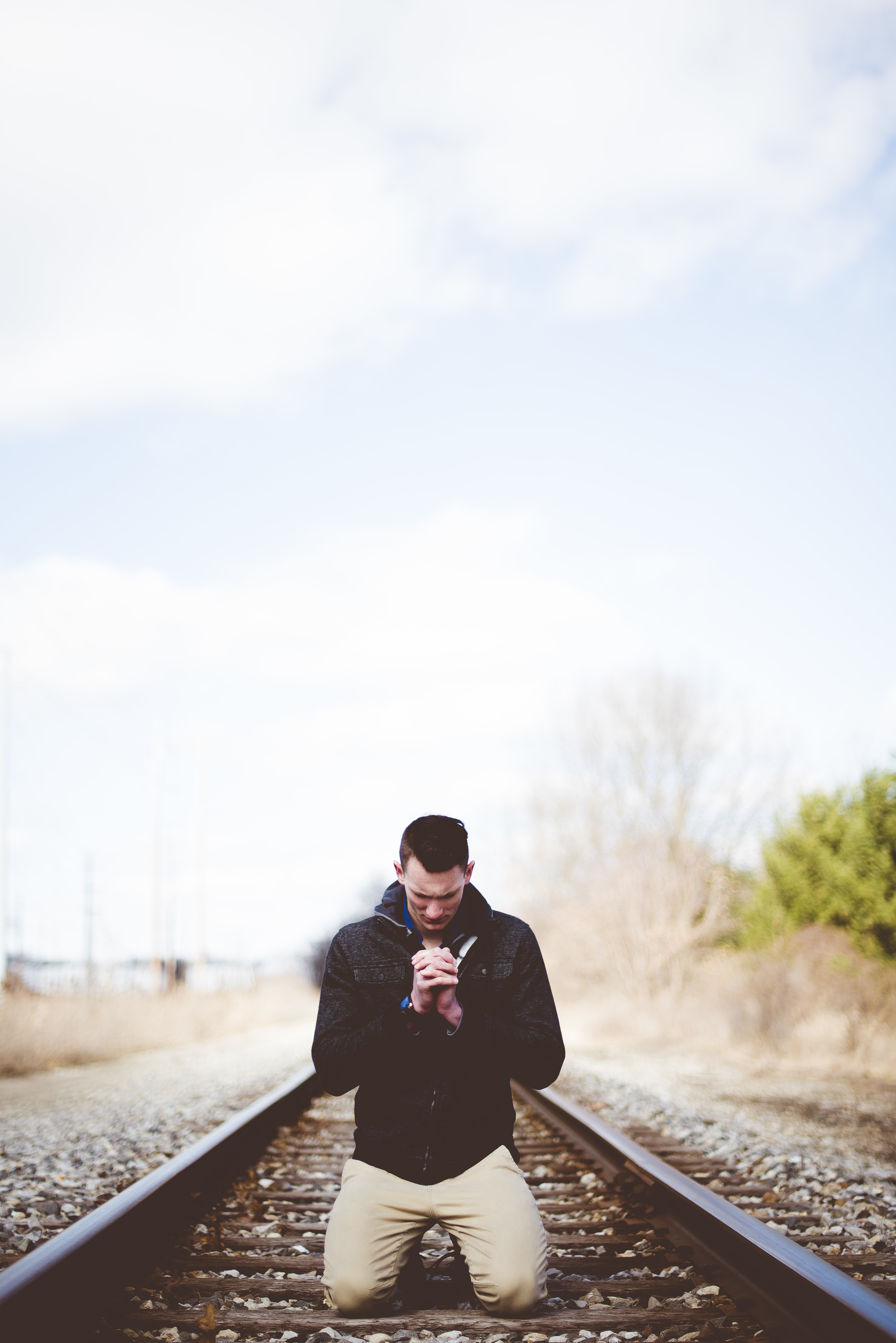 Man praying on railroad tracks