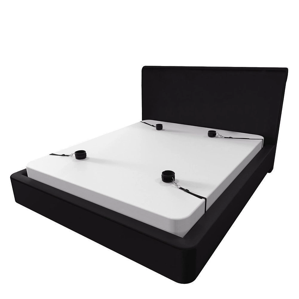 Black under-mattress restraint straps with four cuffs on a white mattress