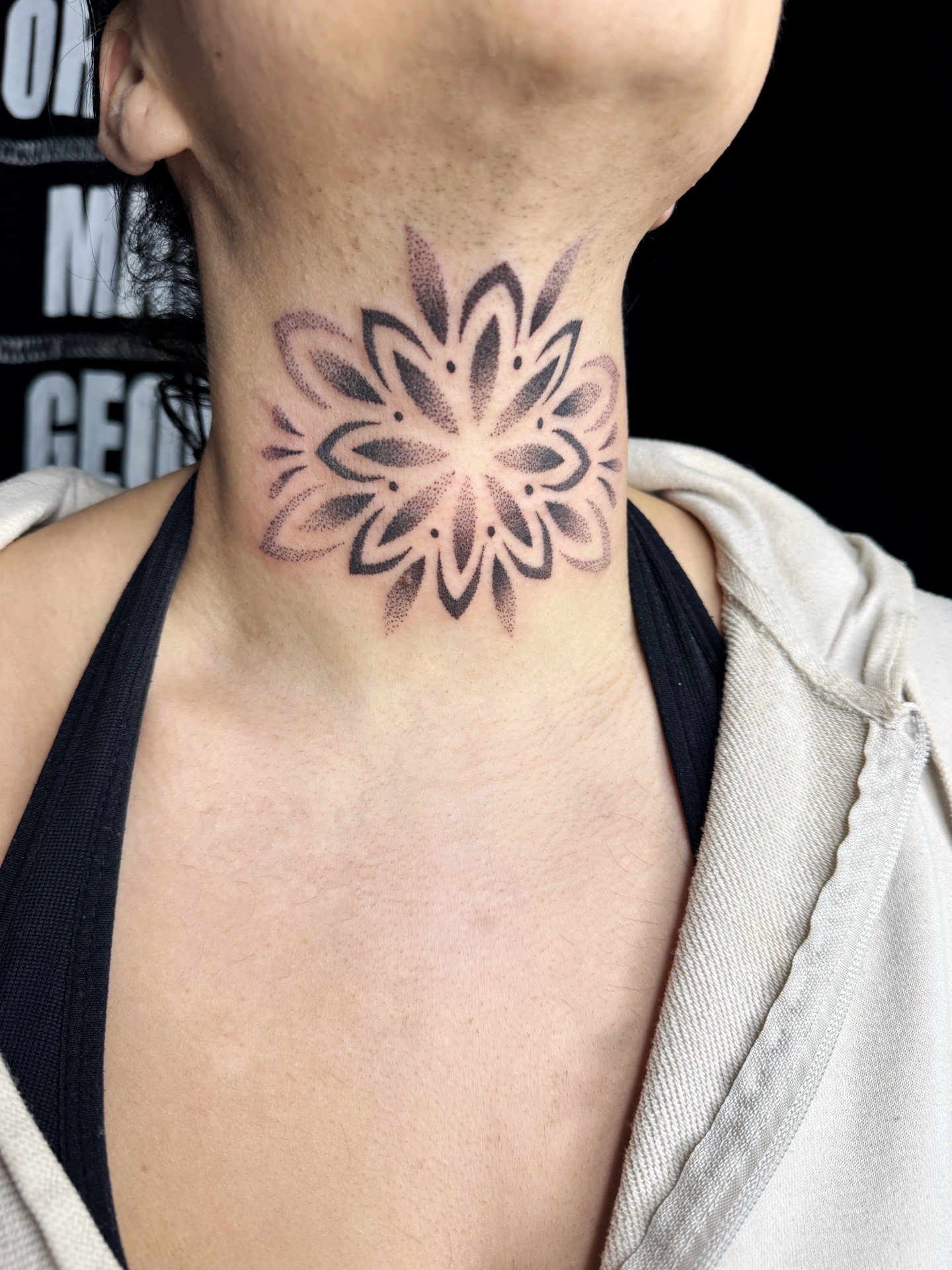 Tatouage mandala sur le cou en style dotwork.