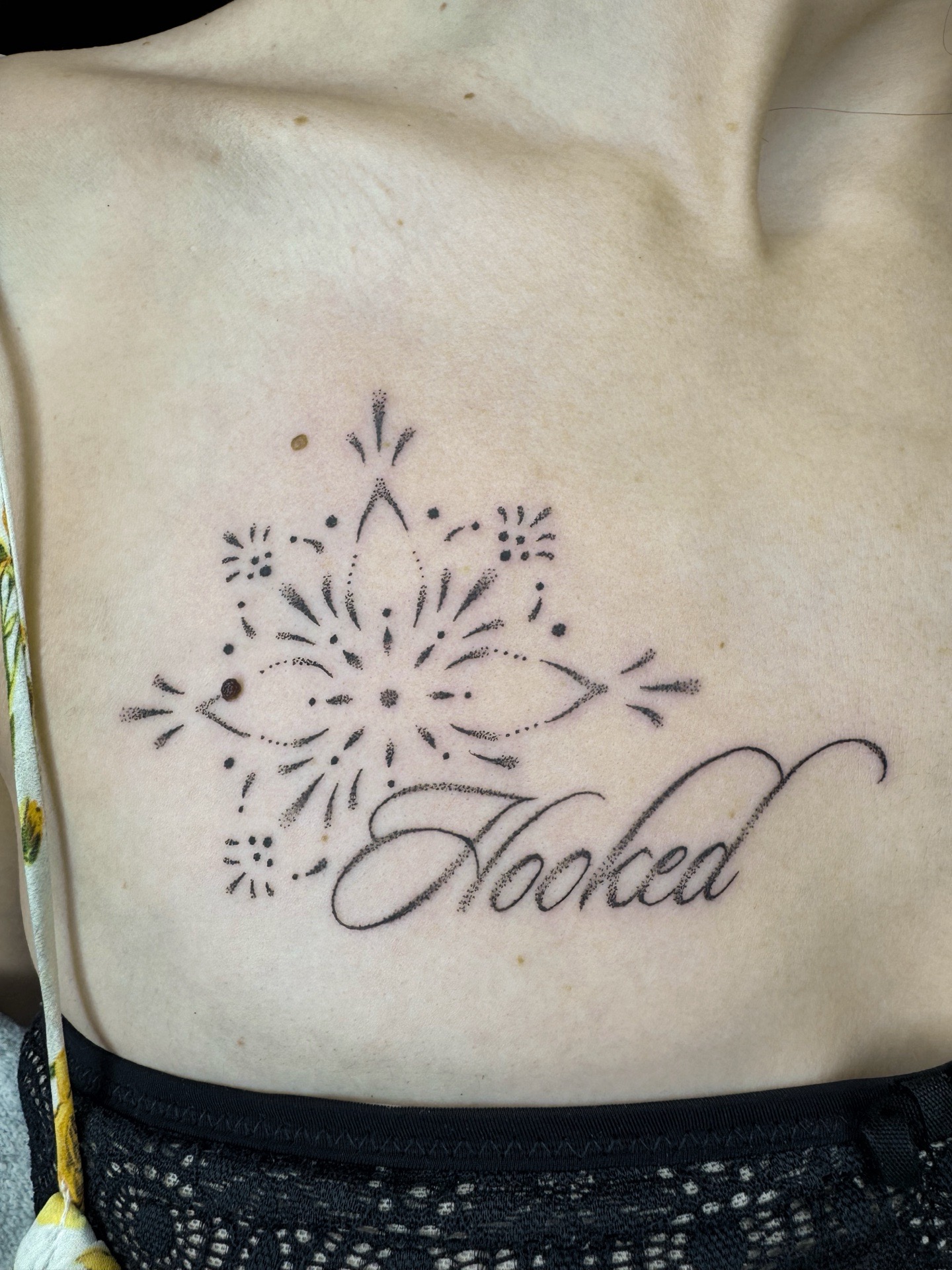 Combinaison de lettrage et de motifs ornementaux en style dotwork.